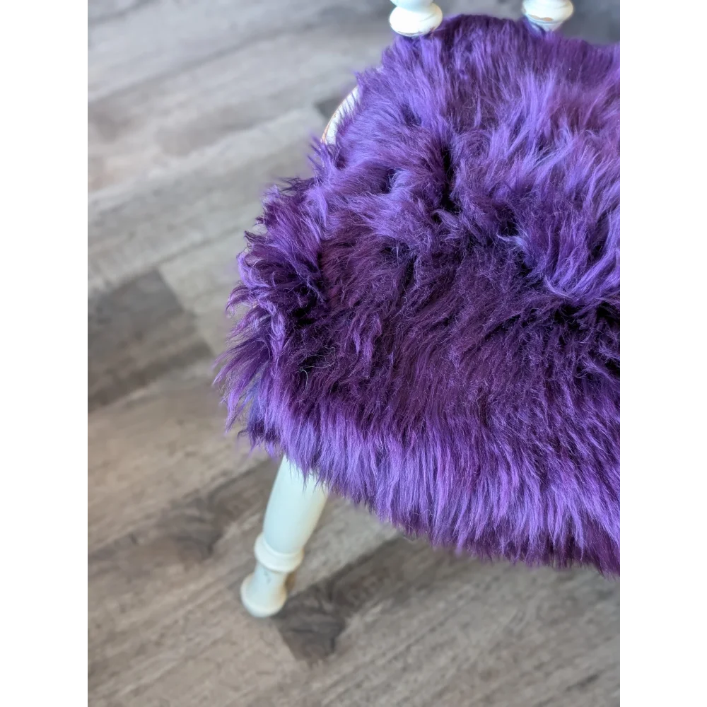 Grape purple merino sheepskin chair pad on faux fur stool with white legs