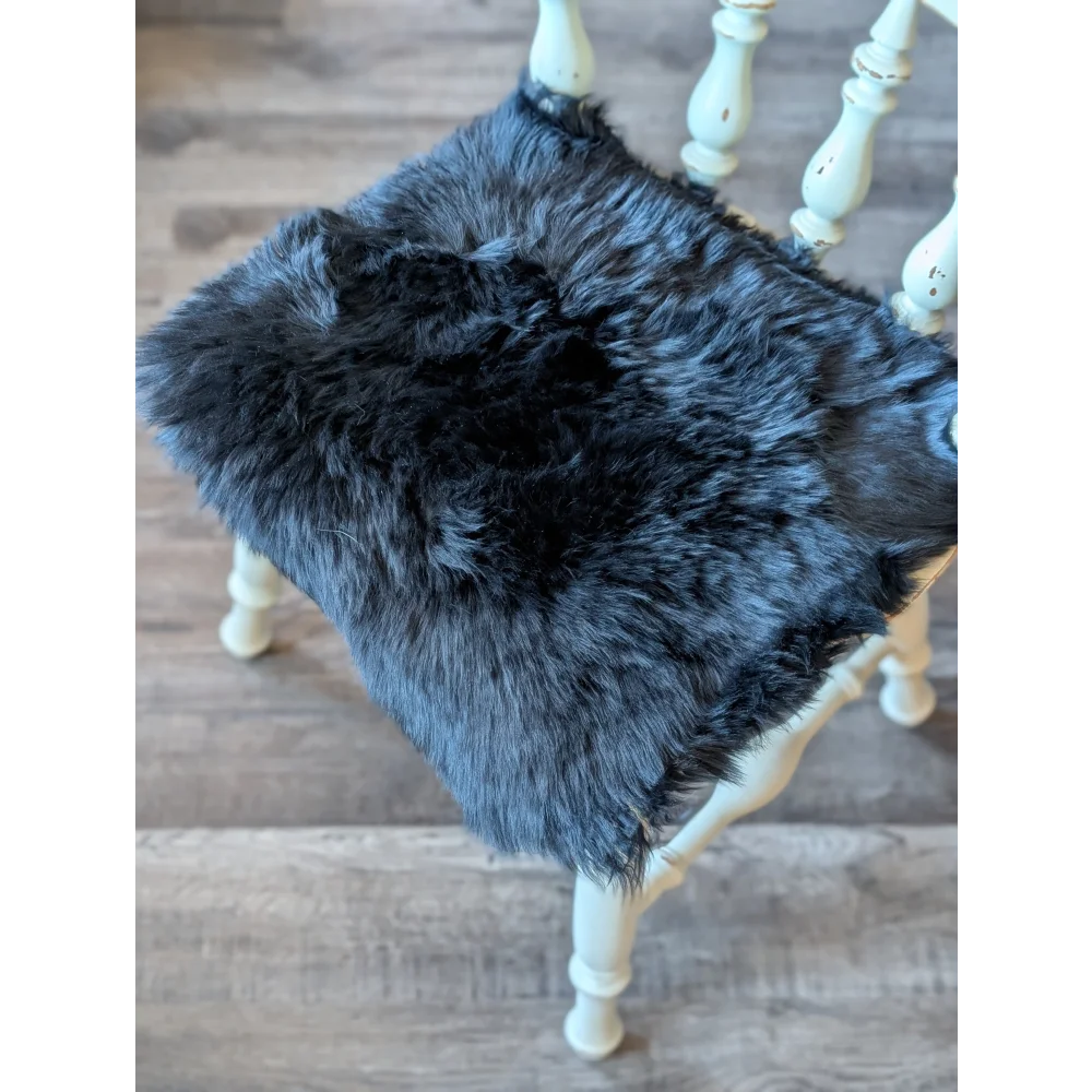 Gorgeous black merino sheepskin chair pad with charcoal gray faux fur, white wooden legs