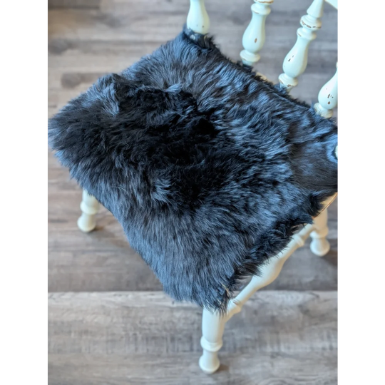 Gorgeous black merino sheepskin chair pad with charcoal gray faux fur, white wooden legs