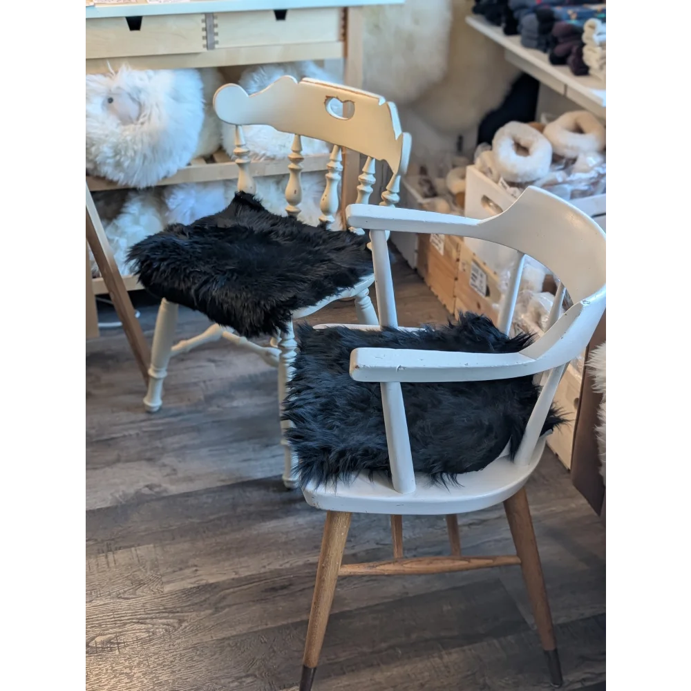 White wooden chair with gorgeous black merino sheepskin pad, strict European standards