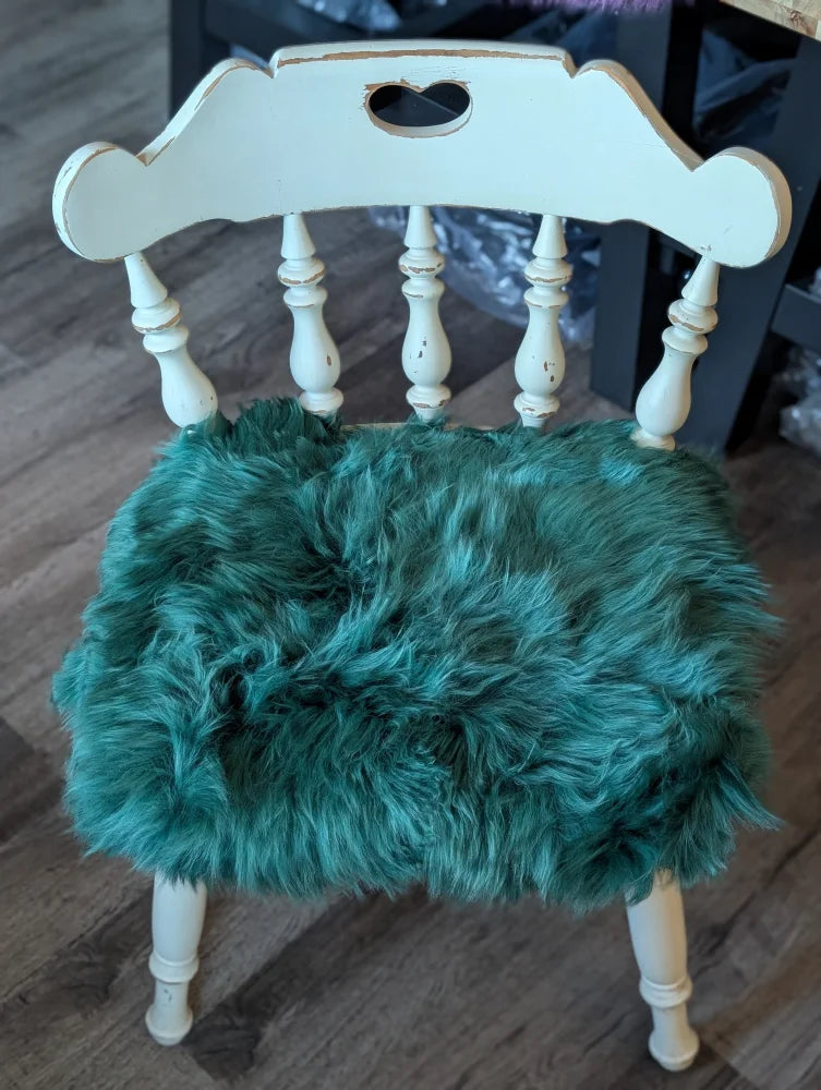 Teal faux fur sheepskin chair pad in gorgeous green merino on white wooden frame