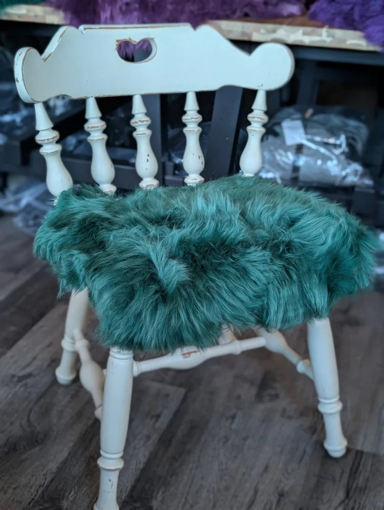 Gorgeous green merino sheepskin chair pad with white wooden spindle back