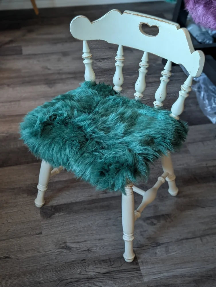 White wooden chair with gorgeous green merino sheepskin pad