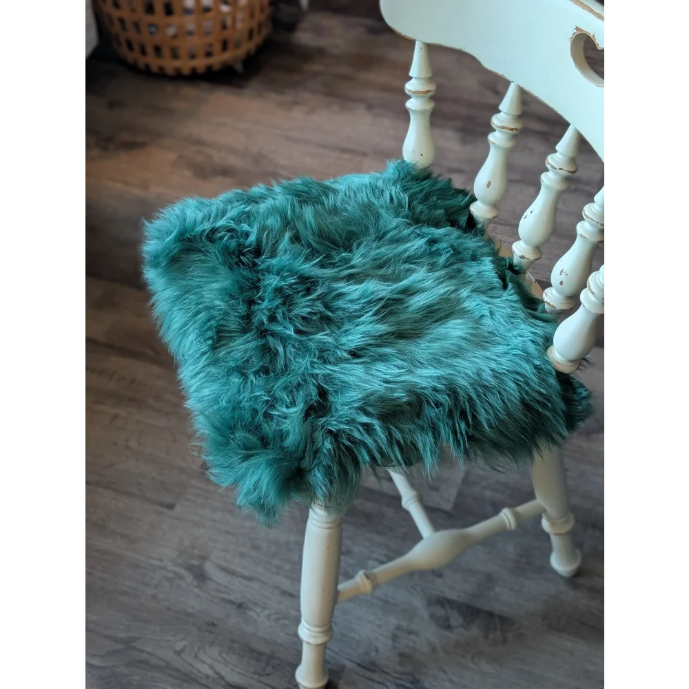 Teal faux fur sheepskin chair pad in gorgeous green merino with white wooden legs