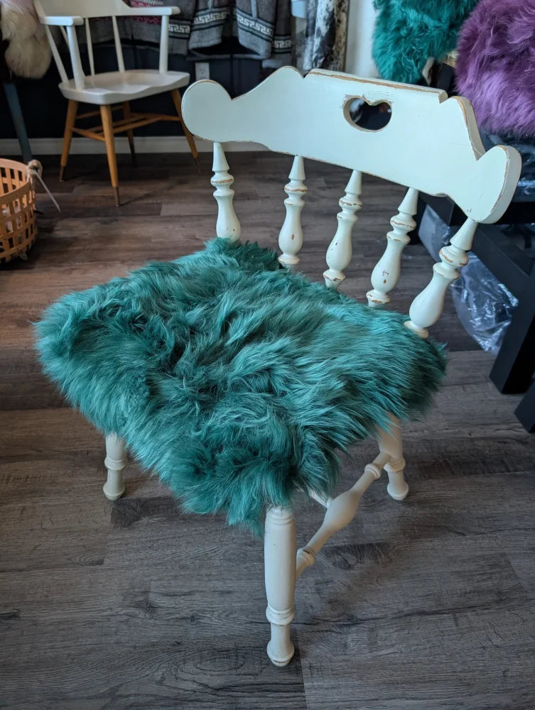 White wooden chair with gorgeous green merino sheepskin pad