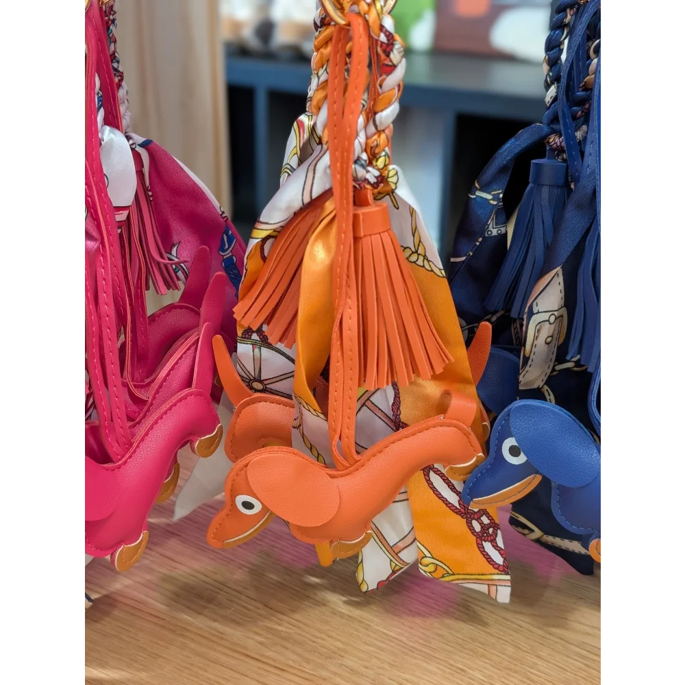 Orange dachshund bag charm with tassel, scarf by Angus Oliver