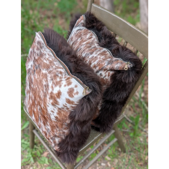 Pair of handmade british sheepskin cowhide cushions with brown and white cowhide and dark brown faux fur trim