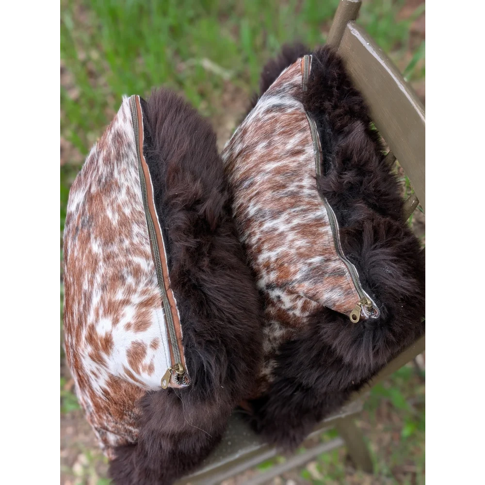 Brown and white spotted cowhide cushion with dark brown faux fur trim handmade british sheepskin style