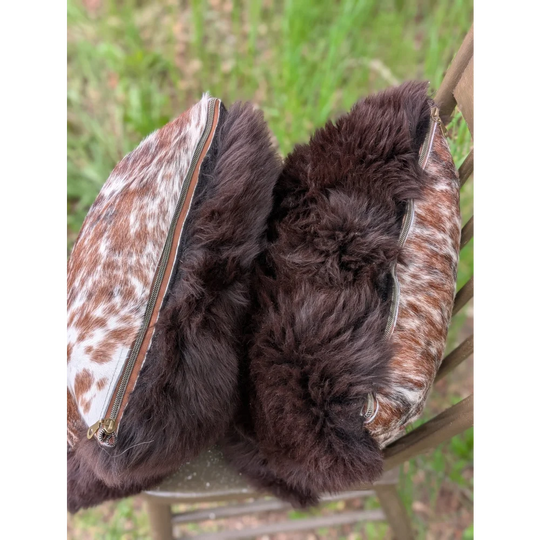 Brown and white cowhide cushions pouch with plush dark brown british sheepskin lining perfect for cozy use