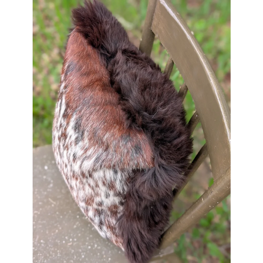 A cozy plush winter hat made of soft brown and white cowhide fur with dark brown fluffy trim perfect for brazilian cowhide cushions