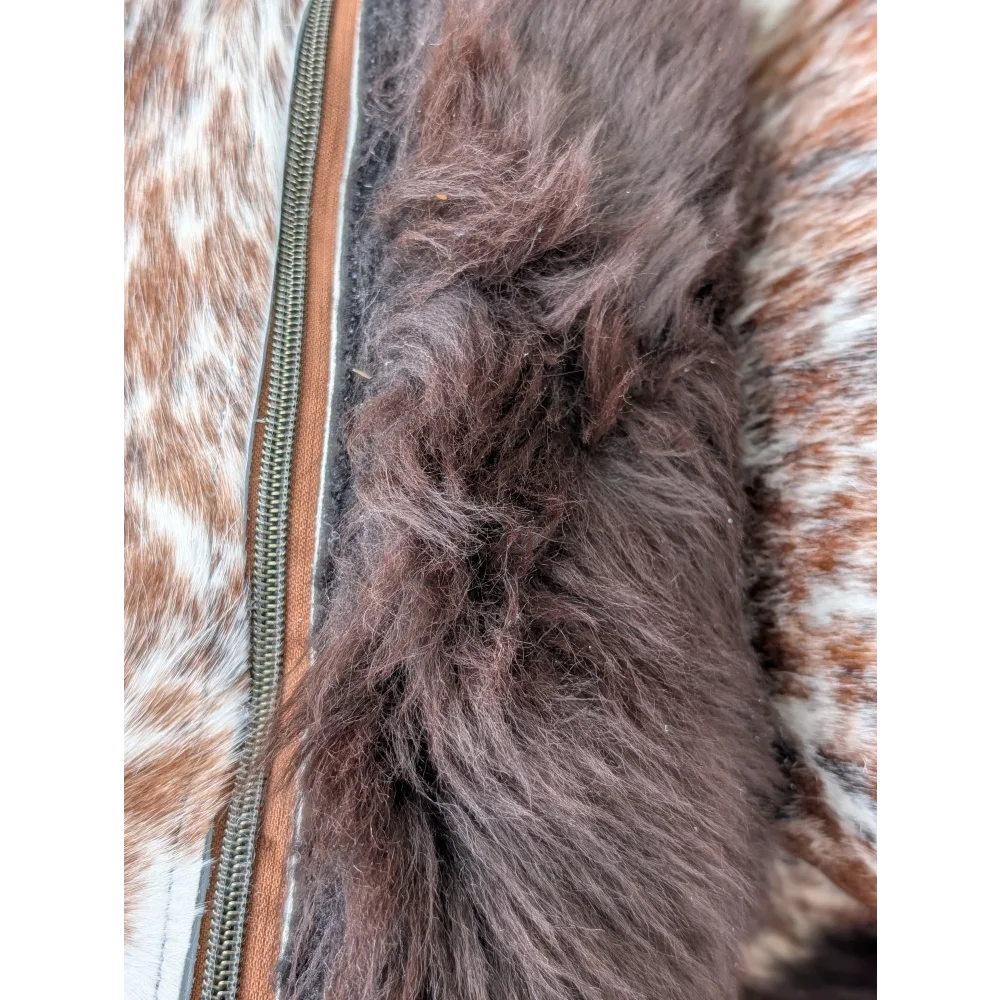 Close up of brown faux fur trim along the zipper of a cowhide jacket on british sheepskin cowhide cushions