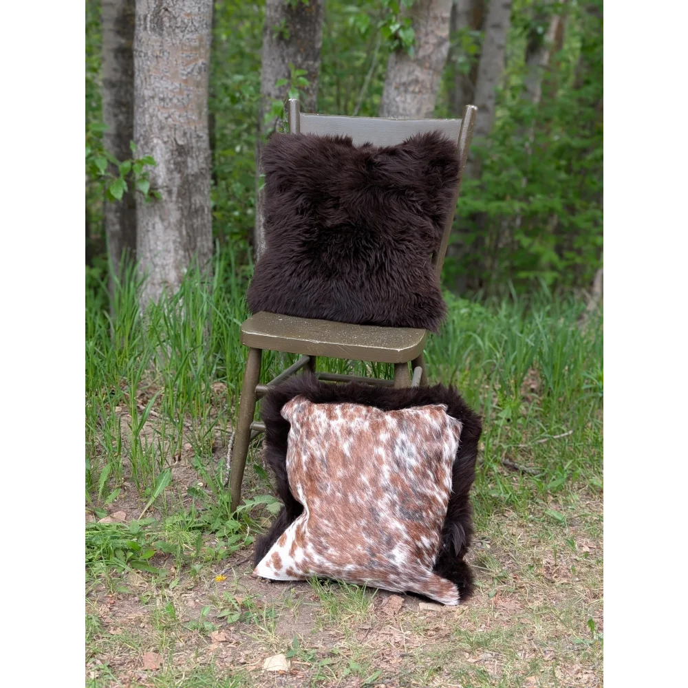 A plush dark brown british sheepskin pillow with soft fluffy texture on rustic wooden chair from handmade cowhide cushions