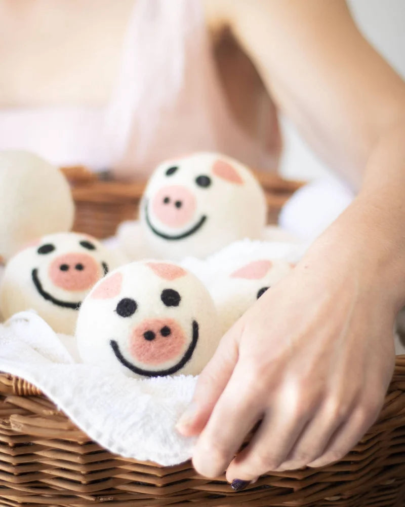 Cute pig trio eco dryer balls in basket with pink icing buns