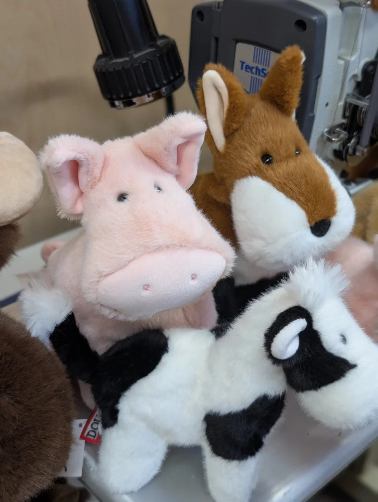 Pink piggies plush pig with soft fur and embroidered eyes next to brown fox and black and white cow stuffed animals