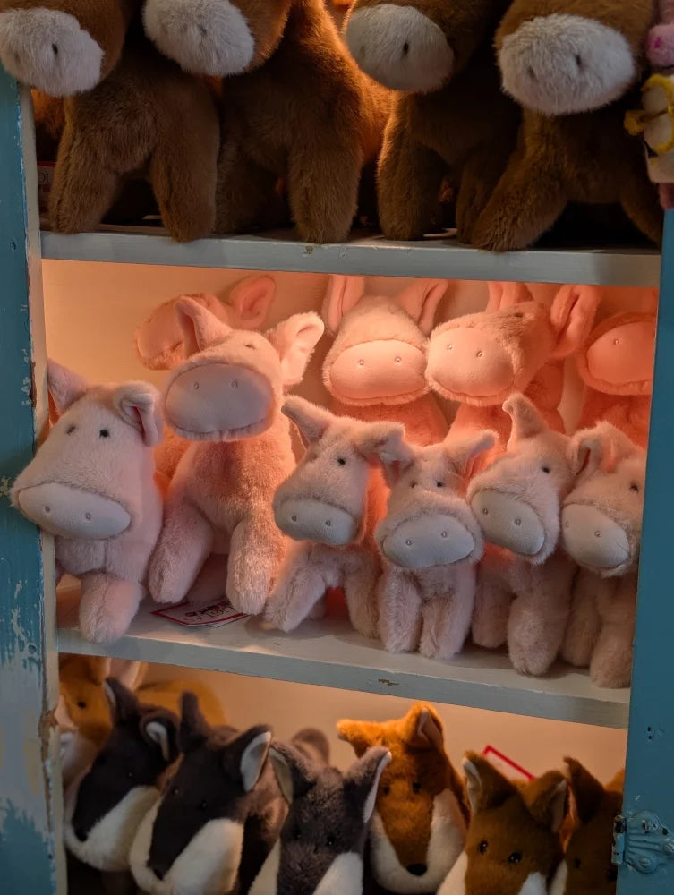 Pink piggies large size plush toys with white snouts and black eyes arranged neatly on a shelf