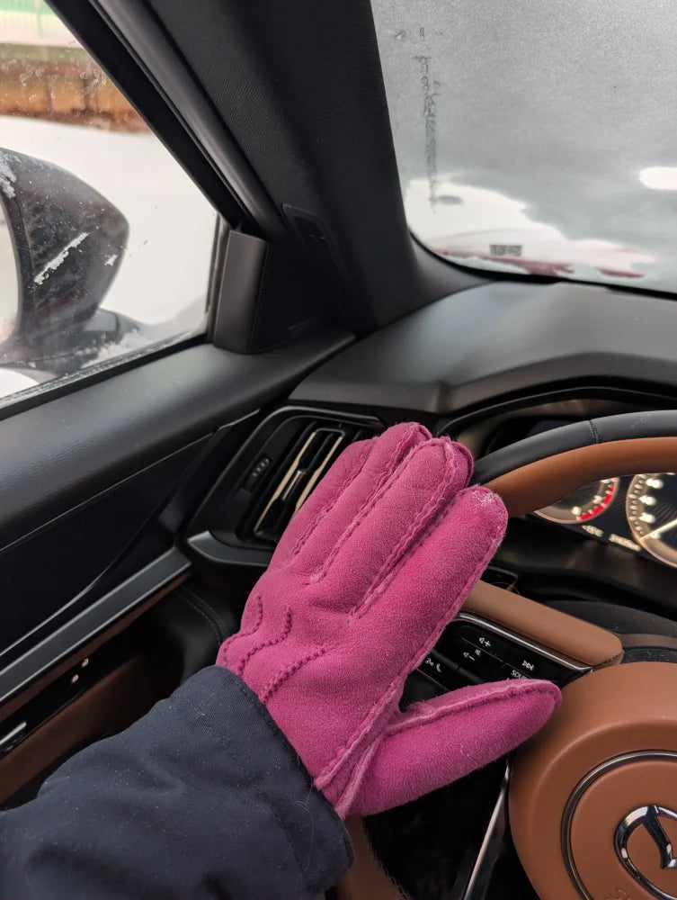 Vibrant pink sheepskins gloves with quilted suede back in car