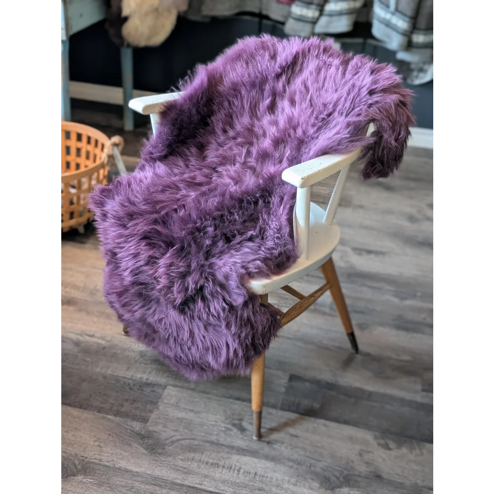 Gorgeous plum purple merino sheepskin throw on white frame chair