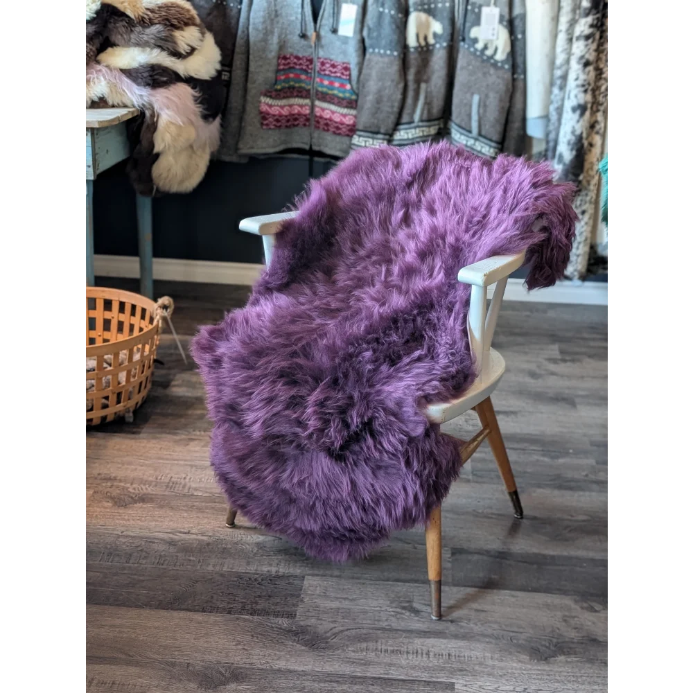 Gorgeous plum purple merino sheepskin throw with wooden legs and white armrests