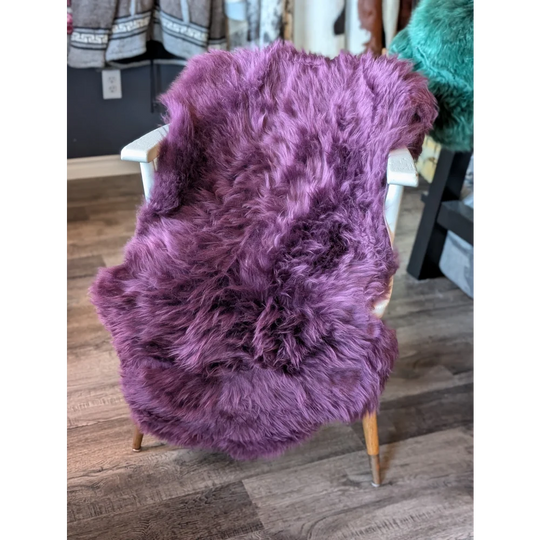 Gorgeous Plum Purple Merino Sheepskin Throw Blanket with Wooden Legs and White Armrests