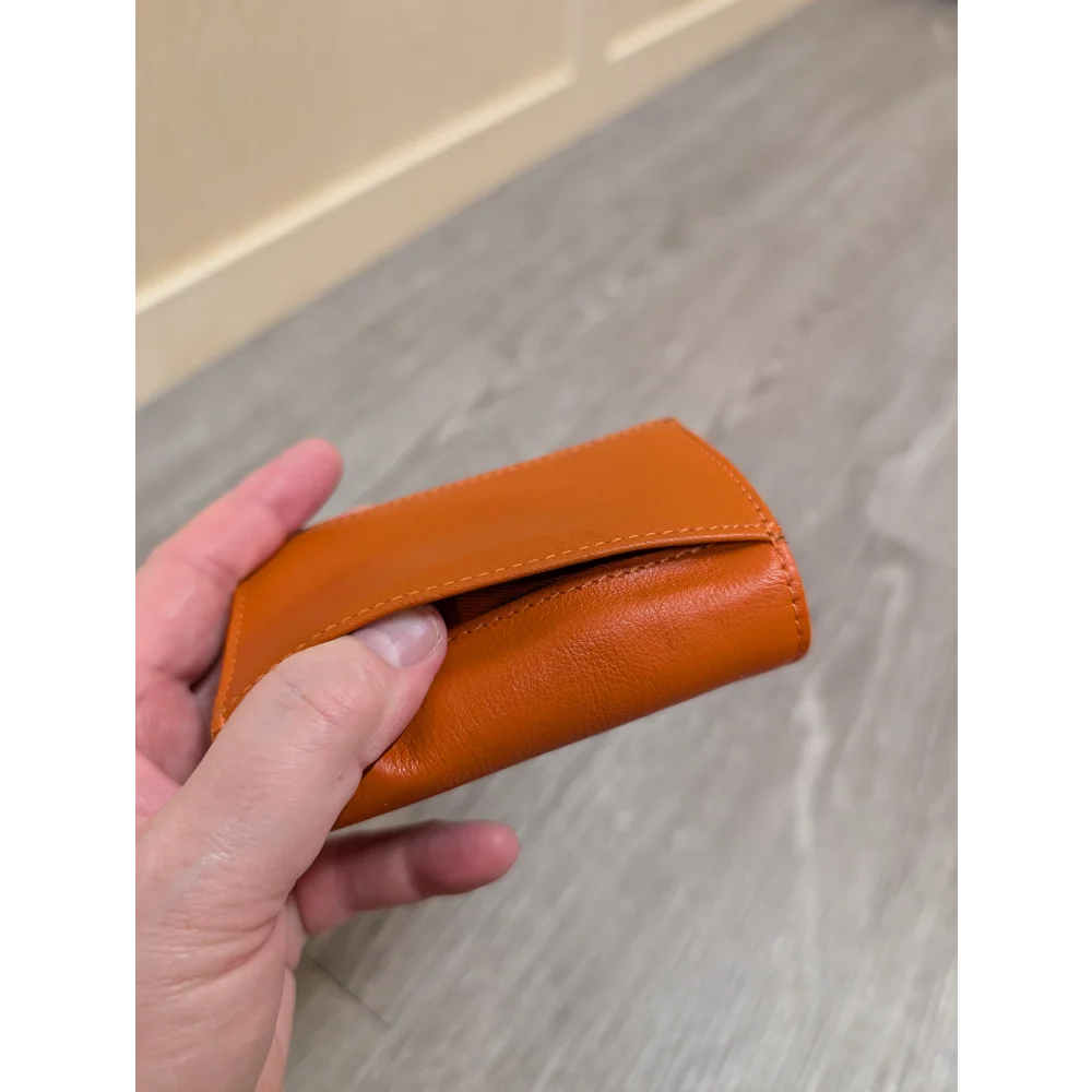 Compact tan leather pocket card holder with smooth texture and stitching