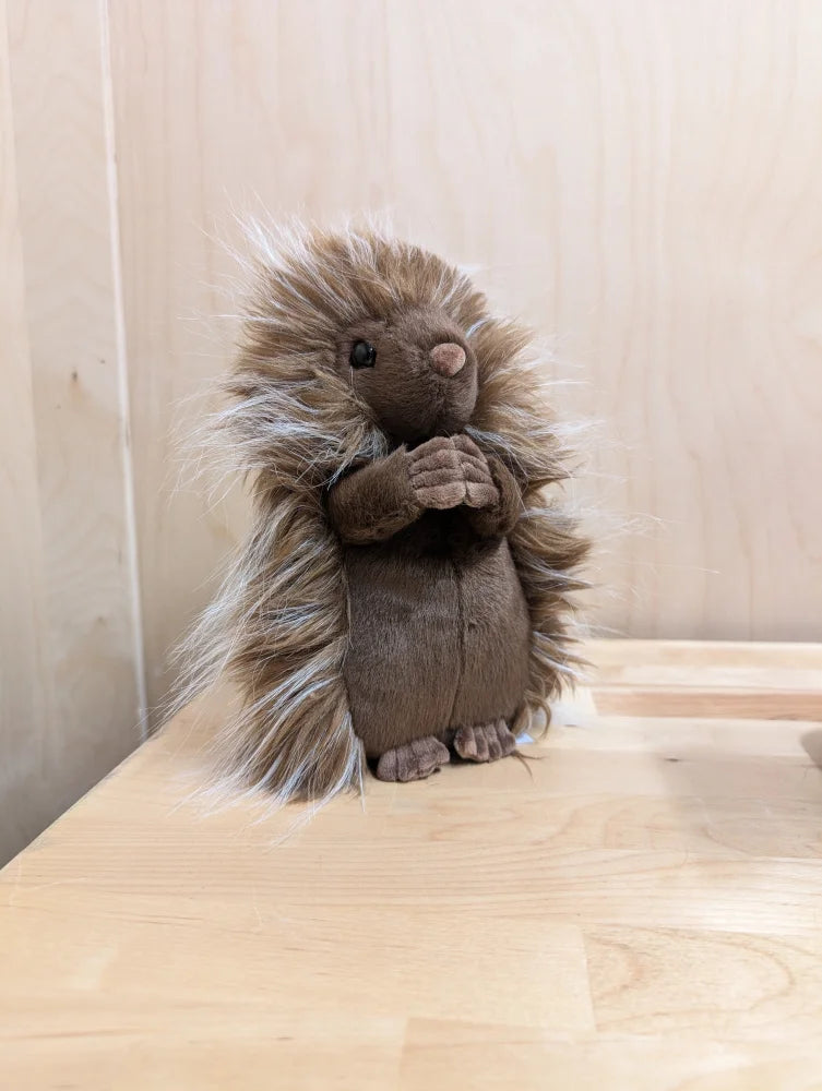 A plush brown porcupine toy called prickle porcupine with soft spiky fur and a gentle expression