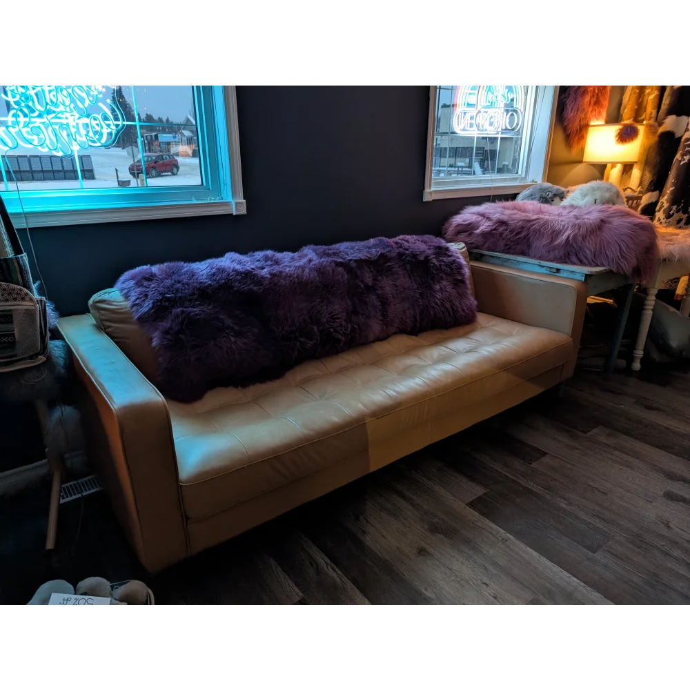 Purple sheepskin area rug 68x35in with tan leather daybed and fur throw