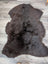 A plush dark brown british isles sheepskin rug with dense fur texture and natural irregular edges arriving soon