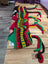 Vibrant red and green wool hats scarf with black accents, cozy sheepskin style