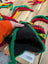 Bright multicolored wool hat with ear flaps and black lining