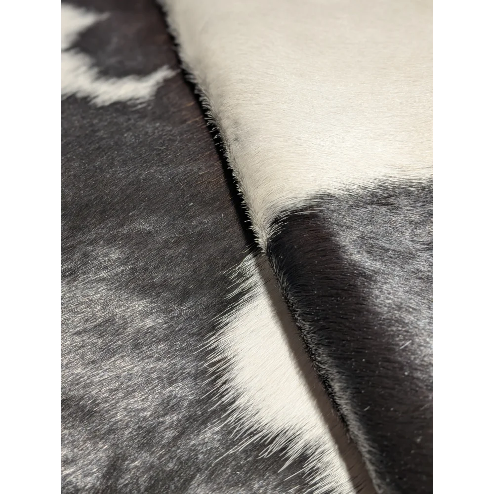 Extra large cowhide rug in black and white fur pattern, textured surface