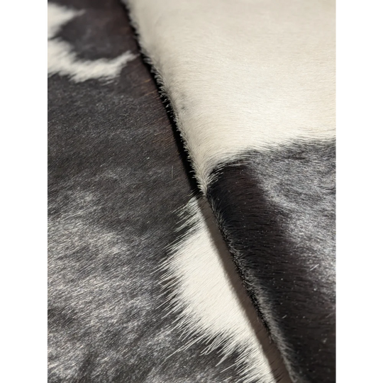 Extra large cowhide rug in black and white fur pattern, textured surface