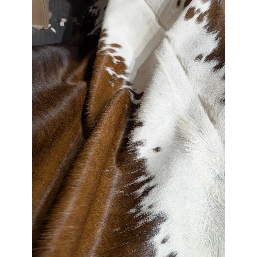 Large reddish brown and white cowhide rug, soft underfoot, 89x80 inches