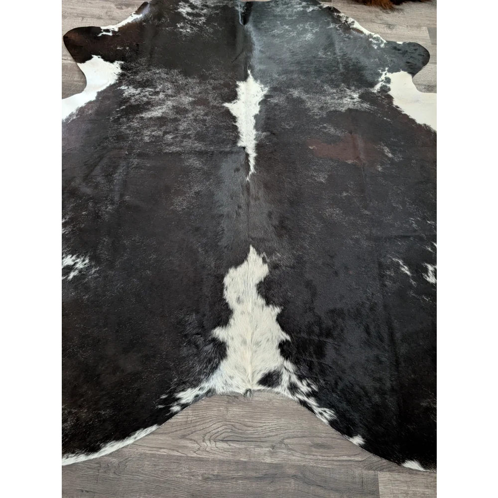 Extra large black and white cowhide rug with natural irregular patches in a reddish 89 by 77 large cowhide design