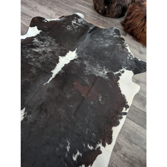 Reddish 476 extra large black and white cowhide rug with natural irregular patches measuring 89 by 77 inches