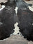 Extra large black and white cowhide rug with natural irregular patches in a reddish 89 by 77 large cowhide design