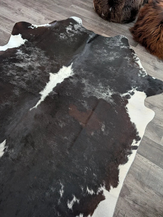 Reddish 476 extra large black and white cowhide rug with natural irregular patches measuring 89 by 77 inches