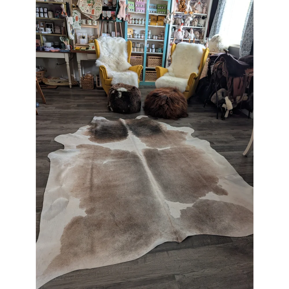 Reddish extra large cowhide rug in brown and white with natural irregular patches measuring 96 by 85 inches