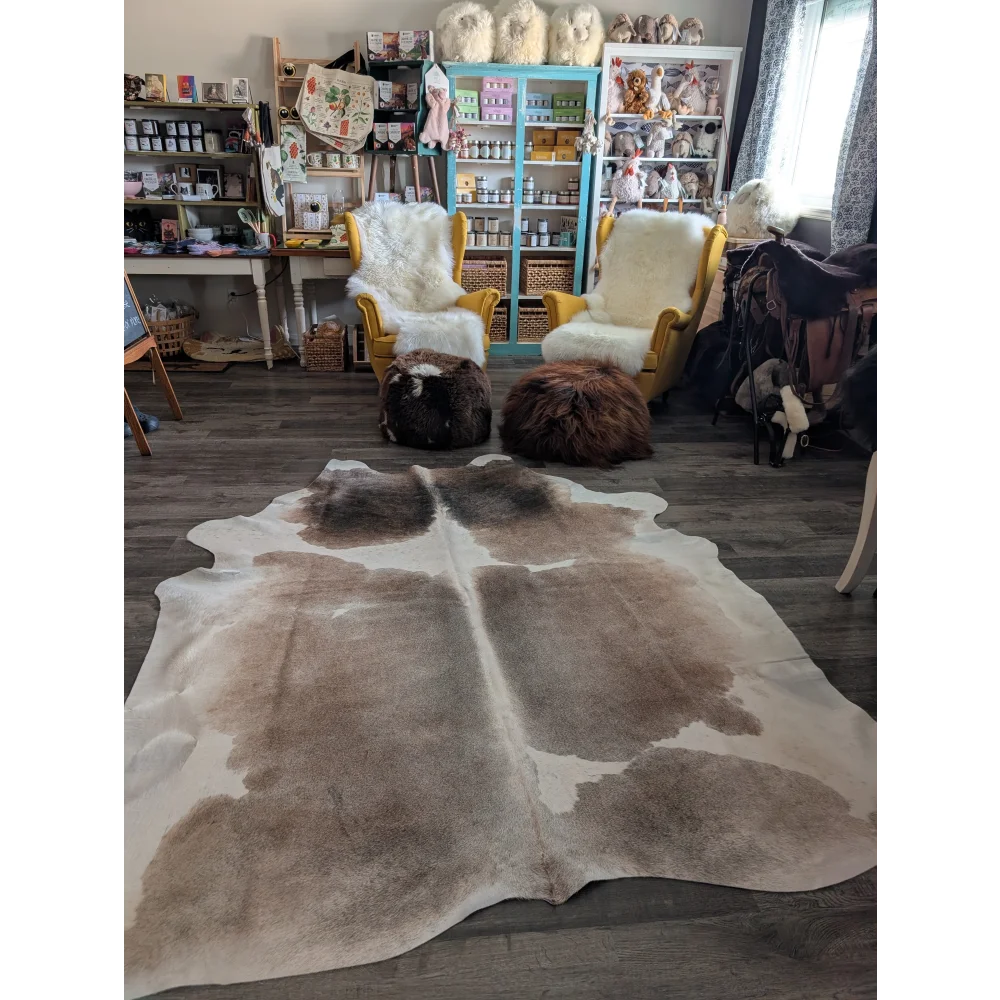 A natural brown and white extra large cowhide rug with a soft textured surface perfect for large spaces