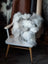 Ridiculously over the top grey sheepskin cushion on white chair