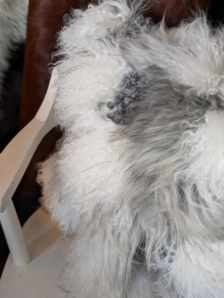 Fluffy grey sheepskin cushion with thick curly fur