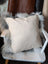 Cream-colored grey sheepskin cushion on white wooden chair