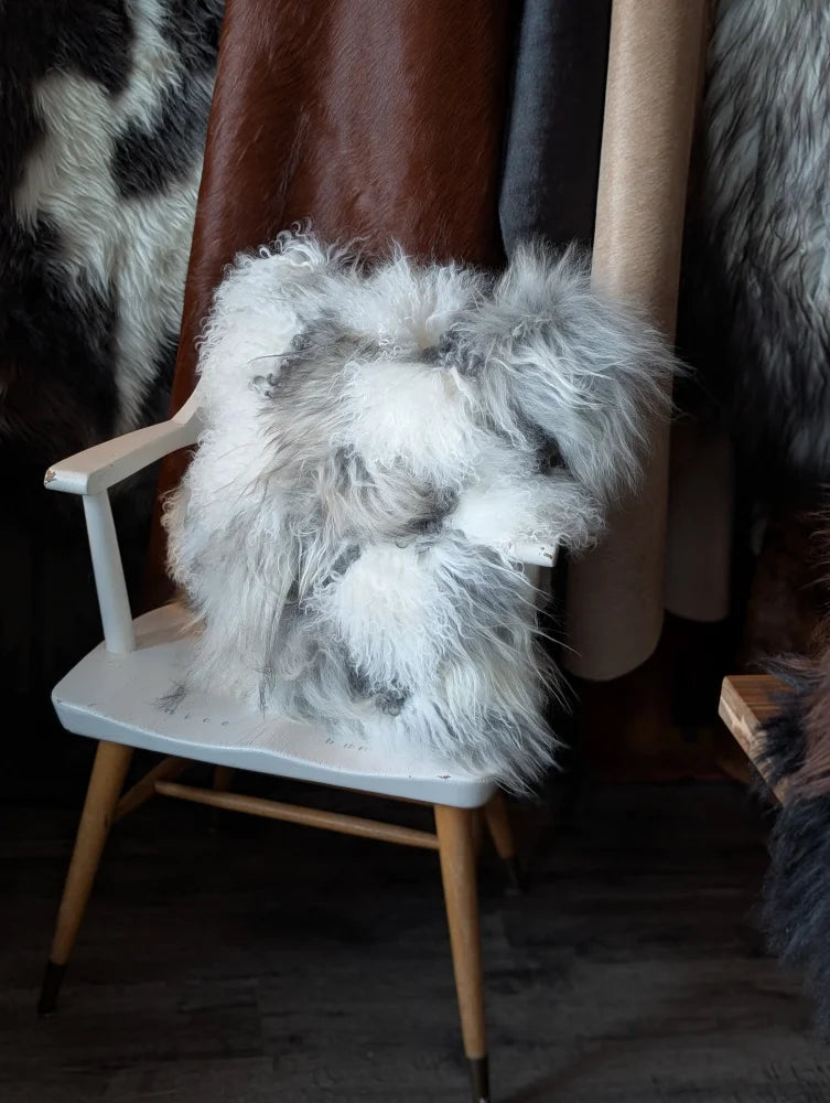 Ridiculously over the top grey sheepskin cushion on white chair