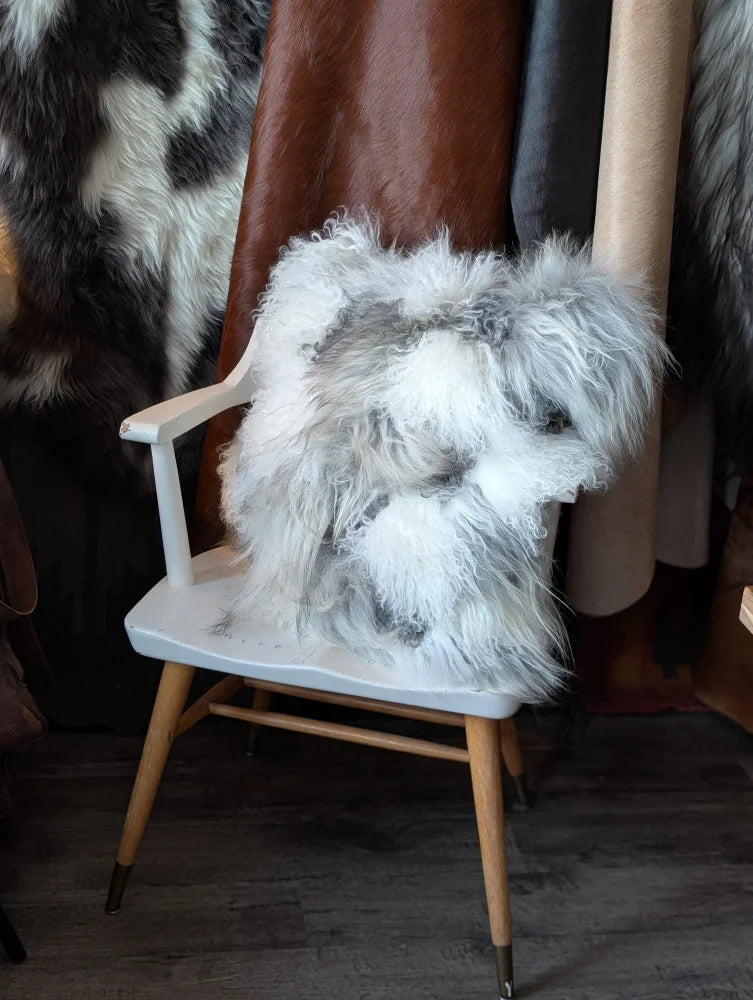 Ridiculously over the top grey sheepskin cushion on white chair