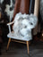 Ridiculously over the top grey sheepskin cushion on white chair
