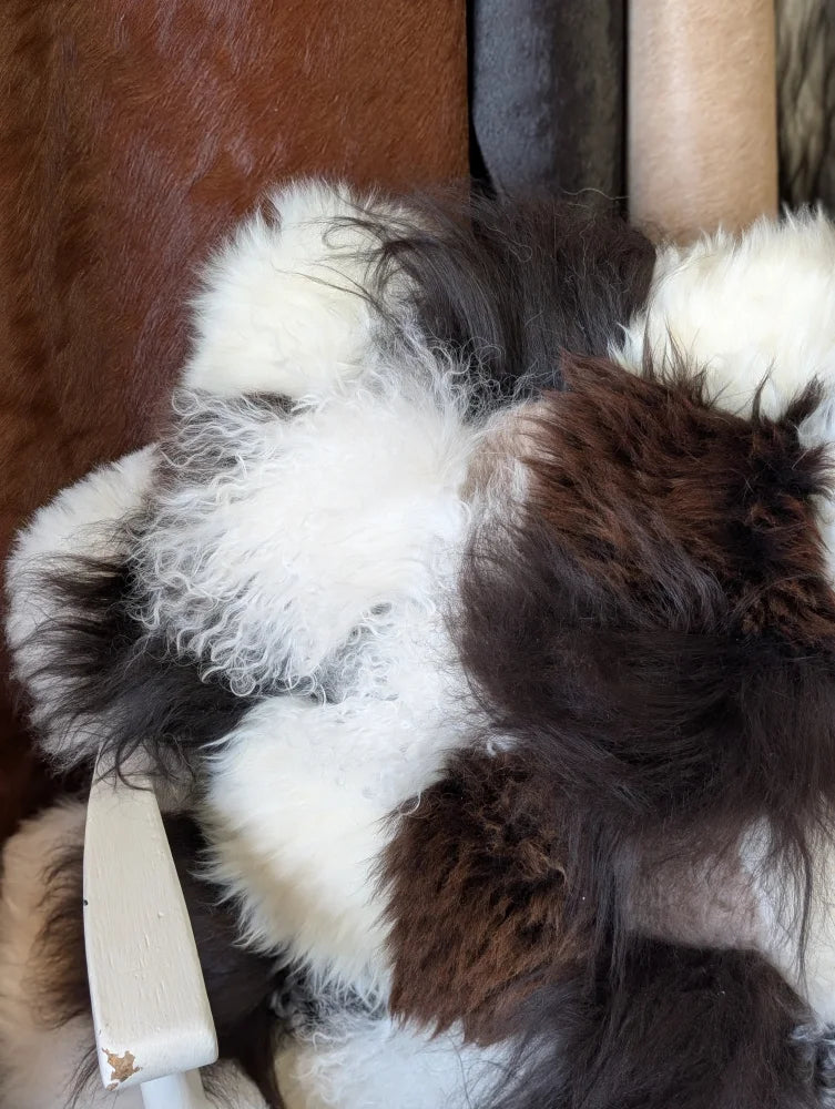Ridiculously over the top sheepskin cushion with plush curly white and dark brown fur