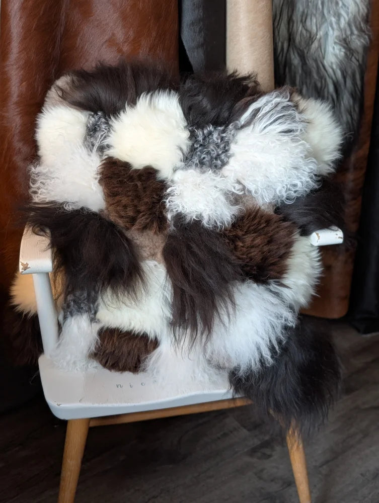 Ridiculously over the top checkered sheepskin cushion on gray chair