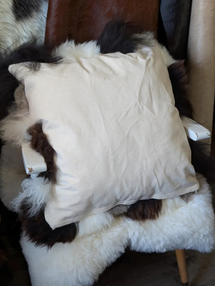 Cream-colored sheepskin cushion on plush cowhide chair