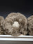 Plush Jellycat sheep toy on sheepskin cushion