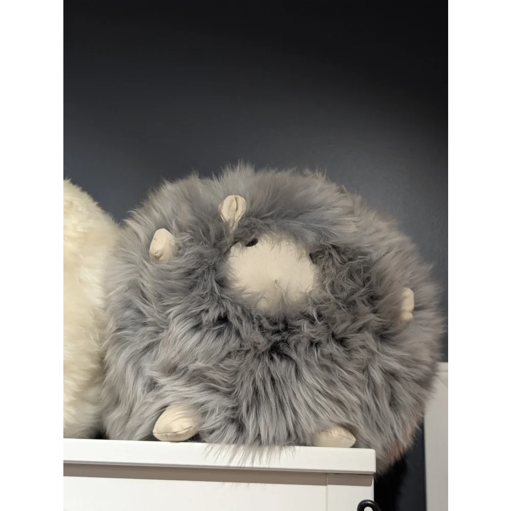 Cute plush sheepskin cushion with gray fur and white face