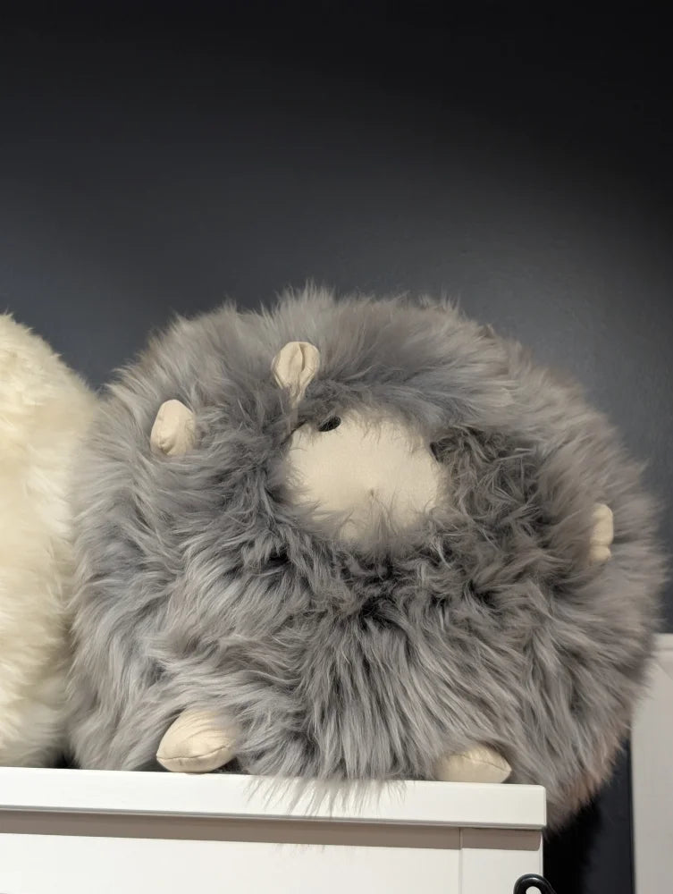 Cute plush sheepskin cushion with gray fur and white face